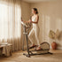 Person using the HomeFlow Elliptical in a sunlit minimalist beige room